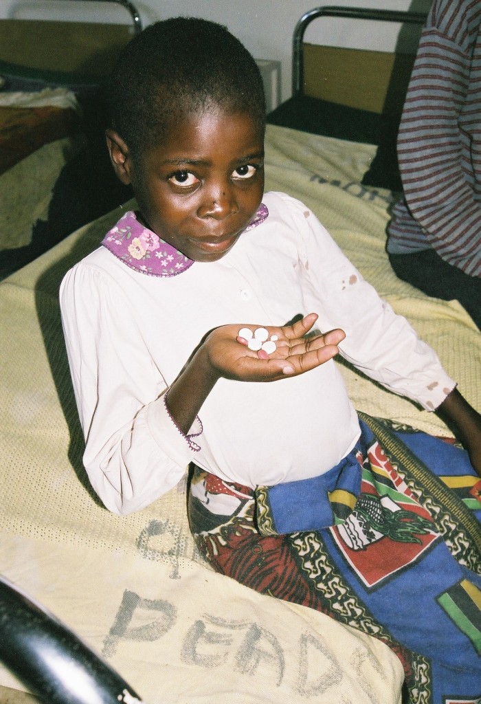 Child holding TB medication, Malawi