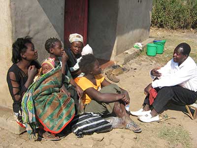 An outreach worker with a family on door to door visits